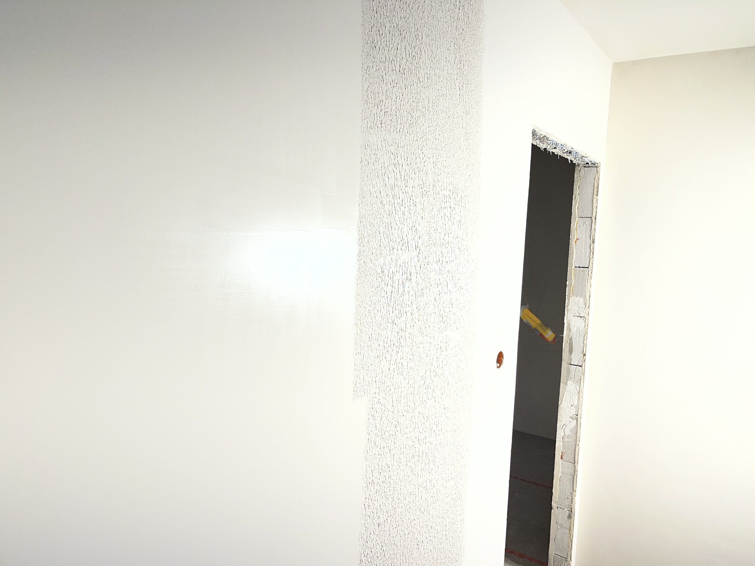 Gładka ściana po gładzi sprawdzona w świetle bocznym, bez nierówności